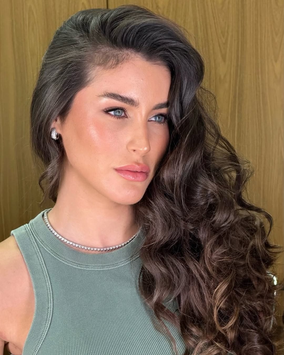 Cabelo escuro em ondas marcadas, com maquiagem
